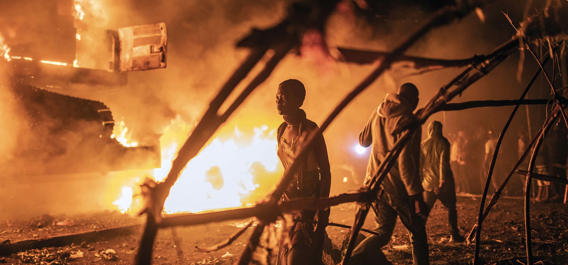 Personas caminan junto a vehículos de la ONU que fueron incendiados en Goma, República Democrática del Congo, el martes 1 de noviembre de 2022. Multitudes enojadas en el este del Congo han incendiado vehículos de la ONU a medida que aumenta la frustración por el avance de los rebeldes del M23 y en medio de falsos rumores de que la ONU había transportado a los rebeldes.
