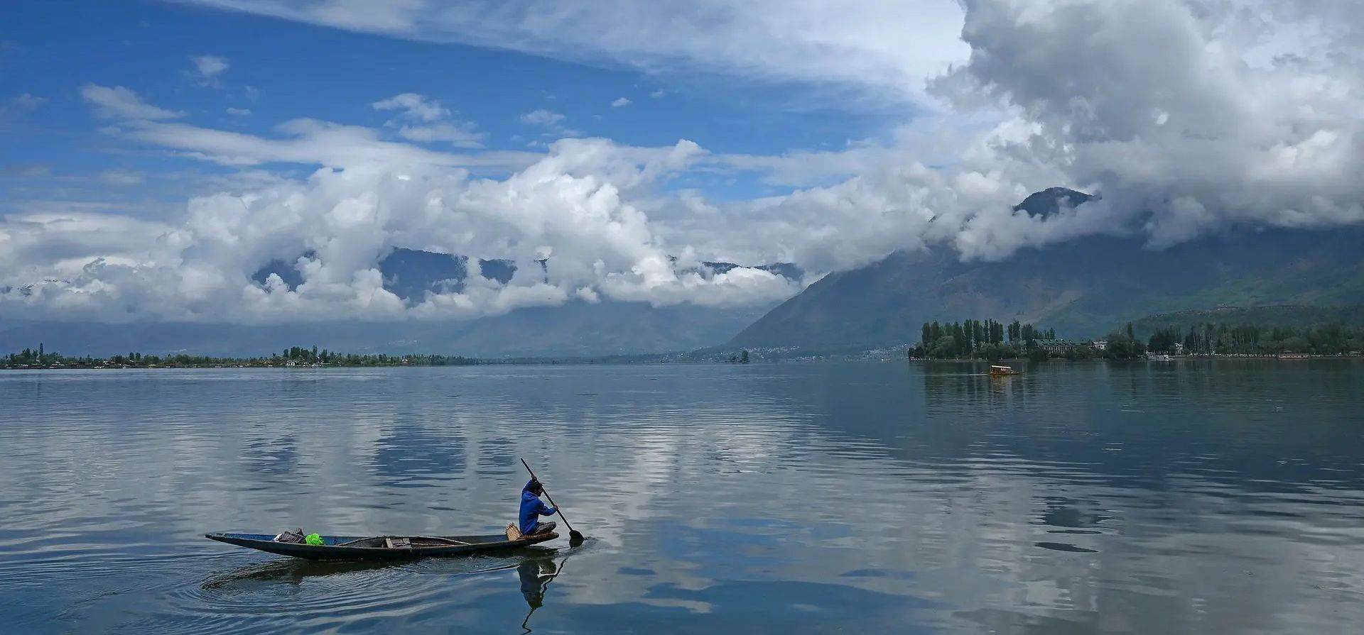 Srinagar, India. Un hombre dirige su barco en un tranquilo lago Dal. Fotografía: Tauseef Mustafa/AFP/Getty Images