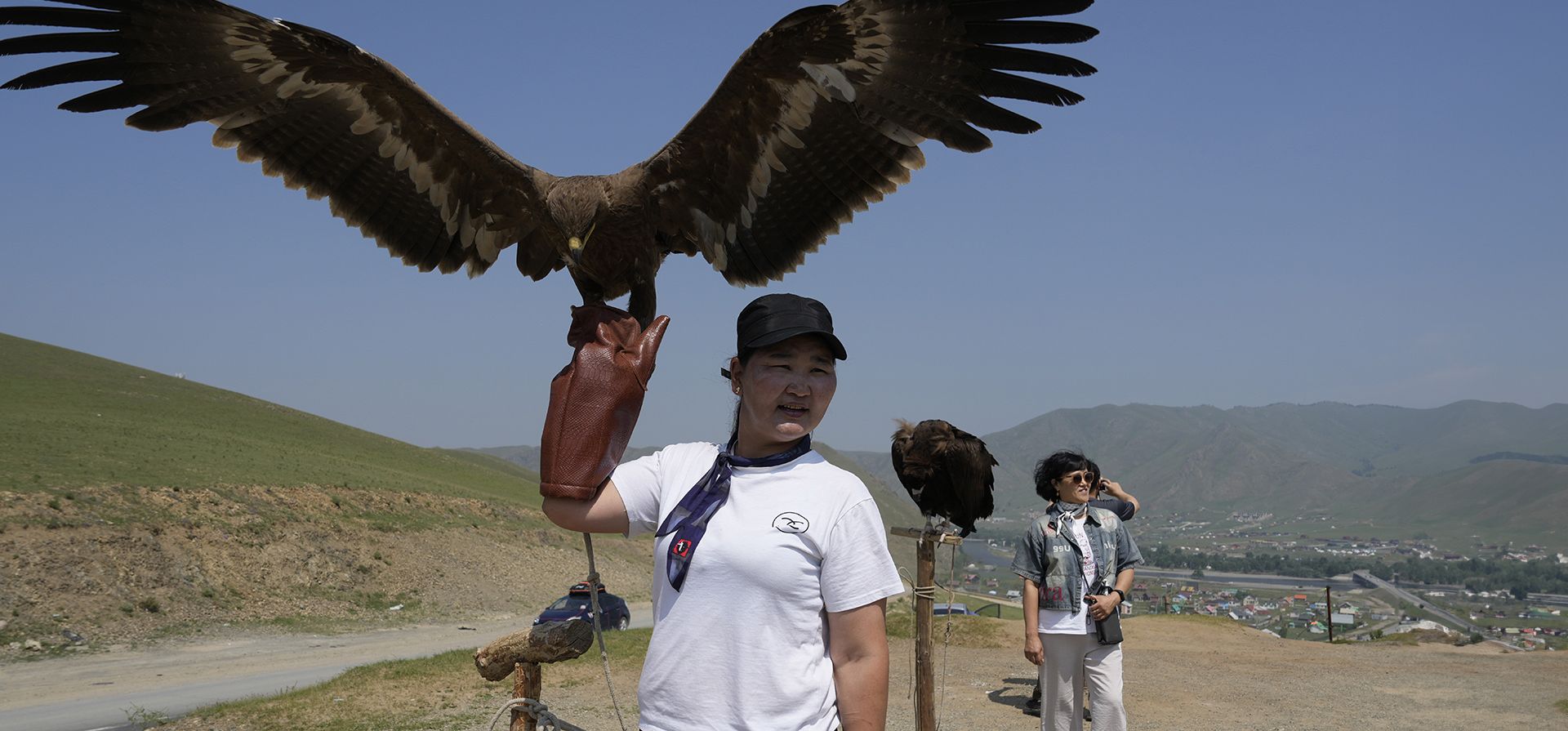 Una mujer mongola sostiene un águila para que los turistas se tomen fotografías en el Parque Nacional Terelj en las afueras de Ulán Bator, Mongolia, el miércoles 3 de julio de 2024. (Foto AP/Ng Han Guan) Una mujer mongola sostiene un águila para que los turistas se tomen fotografías en el Parque Nacional Terelj en las afueras de Ulán Bator, Mongolia, el miércoles 3 de julio de 2024. (Foto AP/Ng Han Guan)