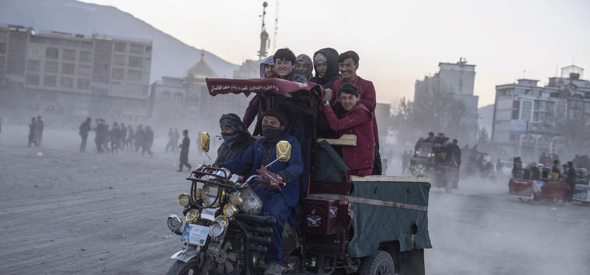 Los espectadores se van en un vehículo de tres ruedas después de ver combates de lucha libre en Kabul, Afganistán. La escena se desarrolla cada semana después de las oraciones del viernes en el extenso parque Chaman-e-Huzori en el centro de Kabul, donde los hombres , principalmente de las provincias del norte de Afganistán, se reúnen para mirar y competir en pahlawani, una forma tradicional de lucha libre.