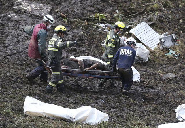Tragedia. Los rescatistas transportan una víctima fatal desde el lugar del impacto de la aeronave.