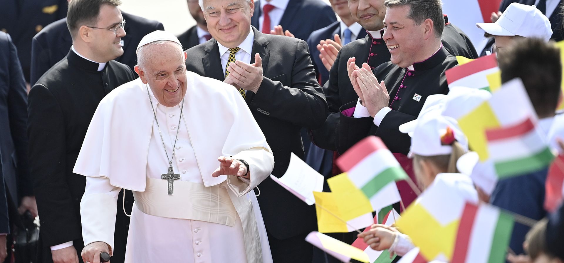 El Papa Francisco es recibido por niños con banderas a su llegada al Aeropuerto Internacional de Budapest en Budapest, Hungría, el viernes 28 de abril de 2023. El Pontífice se encuentra en Hungría para una visita pastoral de tres días. (Foto AP/Denes Erdos)