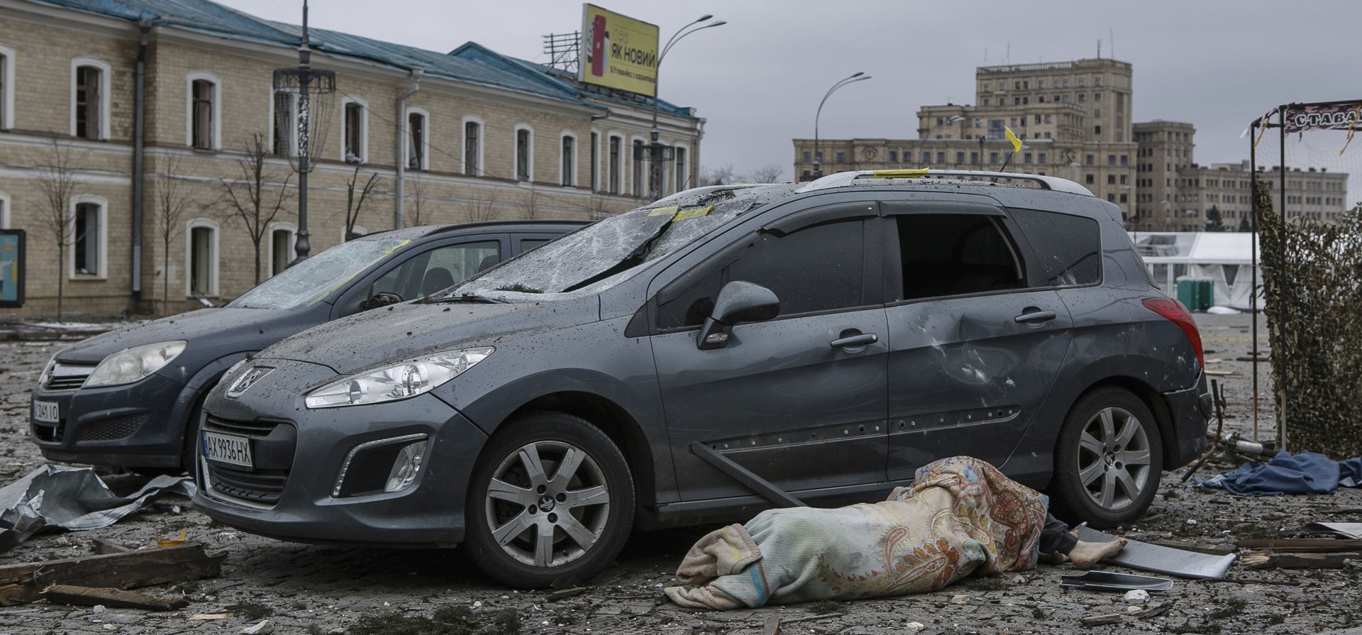 El cuerpo de una víctima yace junto a autos dañados en la plaza central luego del bombardeo del edificio del Ayuntamiento en Kharkiv, Ucrania, el martes 1 de marzo de 2022. Rusia intensificó el martes los bombardeos de Kharkiv, la segunda ciudad más grande de Ucrania, golpeando a civiles objetivos allí. 