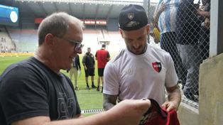 Darío Benedetto firma una camiseta de Newells que le dieron los hinchas en la boca de acceso al vestuario. El Pipa será titular.