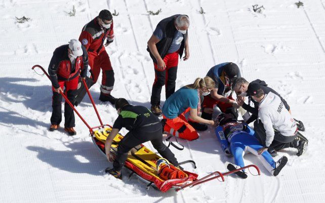 Trabajadores de la salud asisten al noruego Daniel Andre Tande después de que se estrellara durante el evento de la Copa del Mundo individual de vuelo de esquí en Planica, Eslovenia.