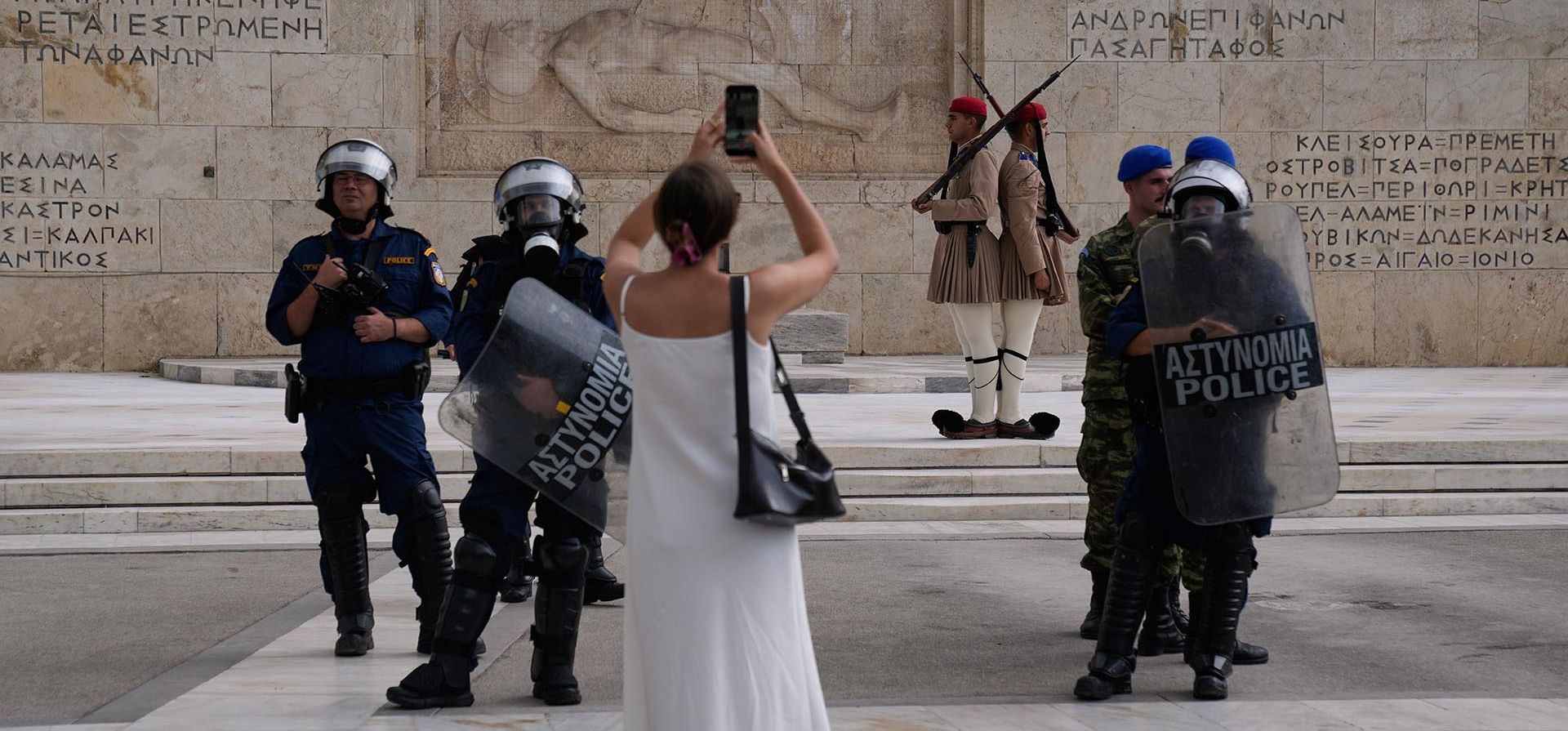 Una mujer toma una foto en el Parlamento griego mientras la policía monta guardia cerca de una protesta durante una huelga nacional de 24 horas en Atenas, Grecia, el miércoles 1 de octubre de 2025. (Foto AP/Petros Giannakouris) Una mujer toma una foto en el Parlamento griego mientras la policía monta guardia cerca de una protesta durante una huelga nacional de 24 horas en Atenas, Grecia, el miércoles 1 de octubre de 2025. (Foto AP/Petros Giannakouris)