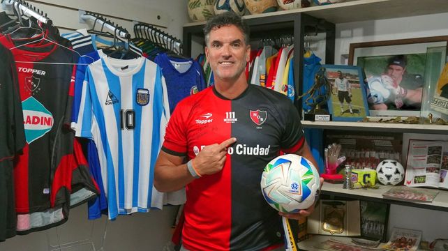 Germán Caffa con la de Newells y en el museo que tiene en su casa plagada de camisetas.