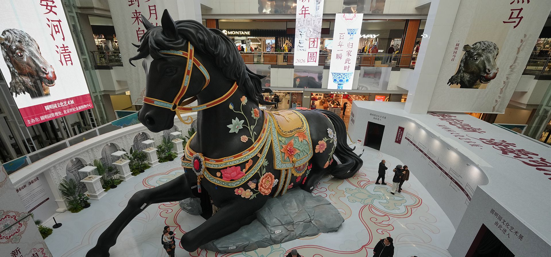 Visitantes recorren una exposición del Palacio de Verano que muestra un caballo gigante para dar la bienvenida al Año del Caballo 2026, según el zodíaco chino, en un centro comercial de Pekín, el lunes 29 de diciembre de 2025. (Foto AP/Andy Wong)