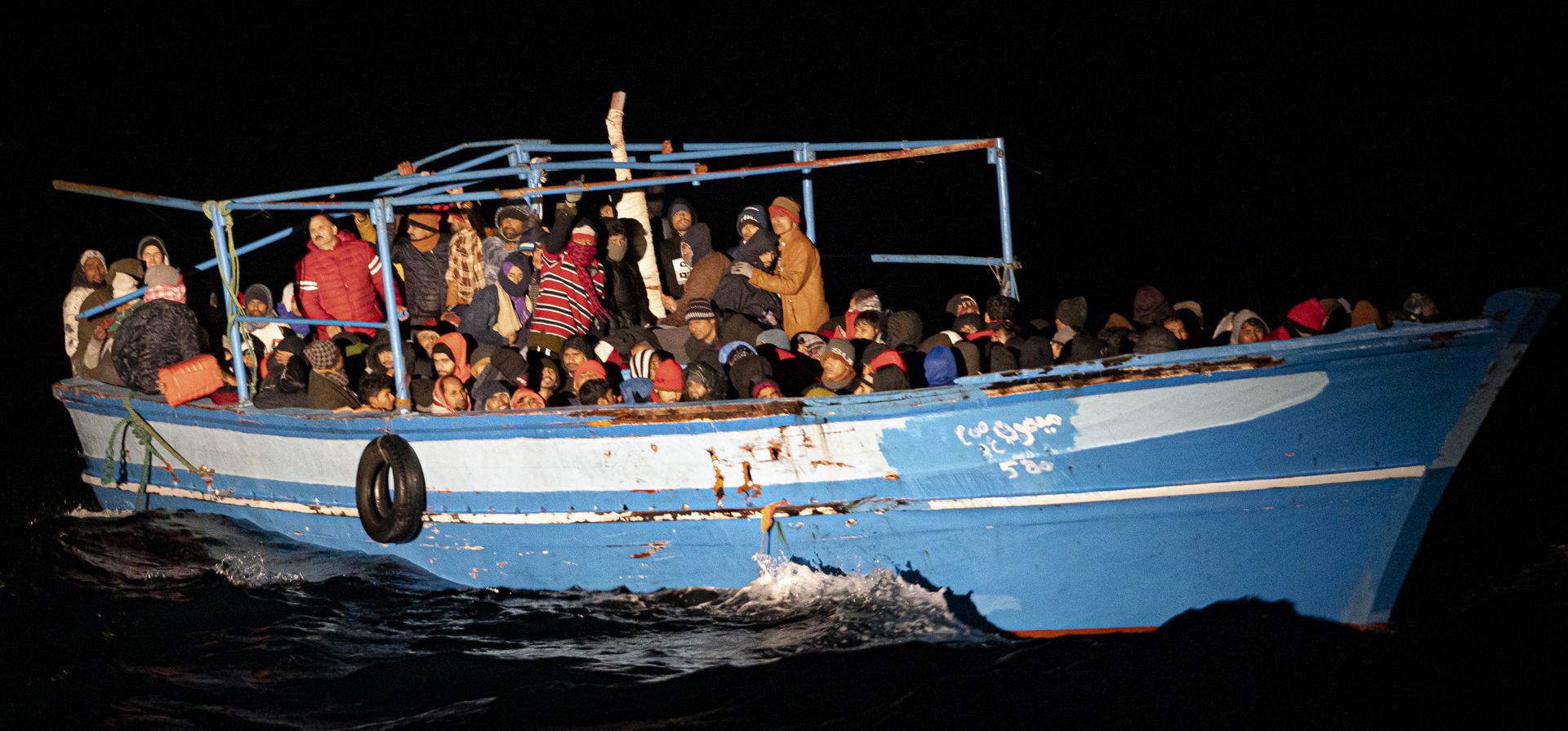 Migrantes esperan ser rescatados frente a la costa de Lampedusa, Italia, el lunes 24 de enero de 2022. Siete migrantes murieron y unos 280 han sido rescatados por la Guardia Costera italiana después de que fueran descubiertos en un bote de madera lleno frente a la costa de Italia.