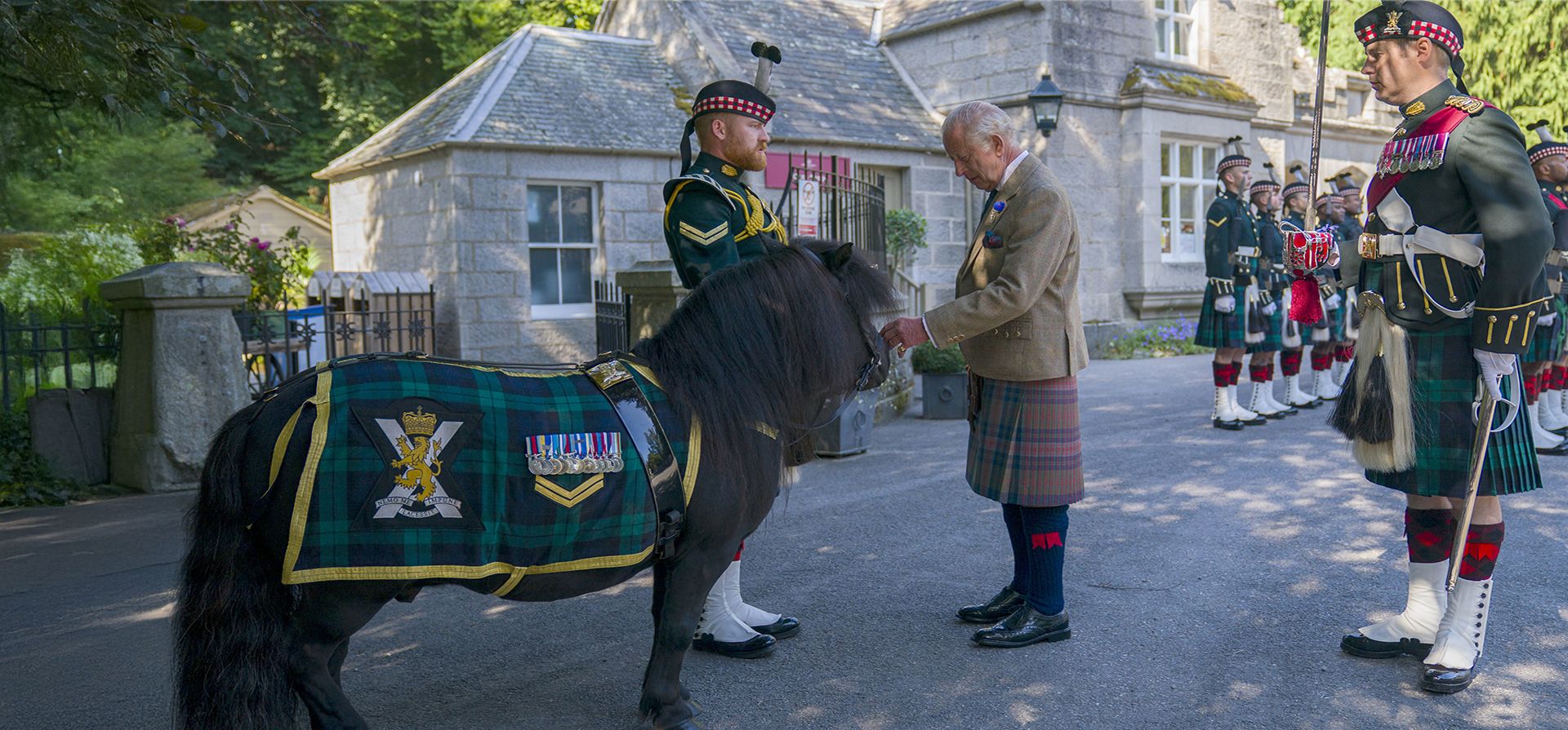 El rey Carlos III de Gran Bretaña se reúne con el poni Shetland cabo Cruachan IV (mascota del Regimiento Real de Escocia) durante una inspección a la Compañía Balaklava, 5º Batallón del Regimiento Real de Escocia, a las puertas de Balmoral, en Aberdeenshire, Escocia, el lunes 18 de agosto de 2025. (Jane Barlow/PA vía AP)