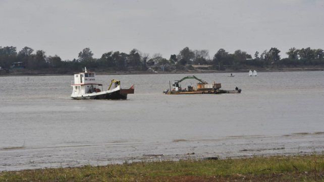 Una draga trabaja sobre el cause del río.