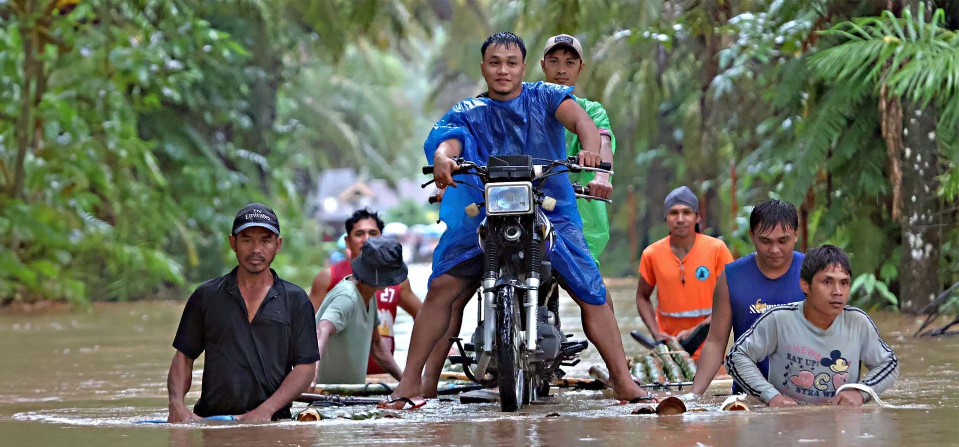La gente empuja una balsa improvisada cargada con una motocicleta a través de las inundaciones provocadas por las fuertes lluvias, Prosperidad, Filipinas. Fotografía: AFP/Getty Images La gente empuja una balsa improvisada cargada con una motocicleta a través de las inundaciones provocadas por las fuertes lluvias, Prosperidad, Filipinas. Fotografía: AFP/Getty Images
