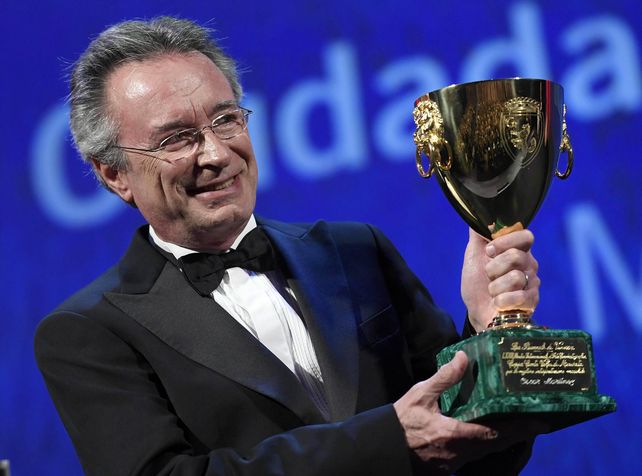 Premiado. El actor sobre el escenario del Palazzo del Cinema y sosteniendo la Copa Volpi que consagra a los grandes.