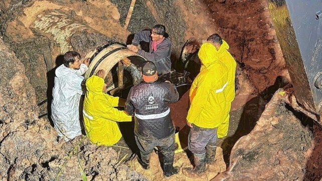 Operarios de la comuna de Paraná trabajan en el colocado de juntas. Las lluvias dificultan las tareas y se requirió la utilización de bombas de extracción
