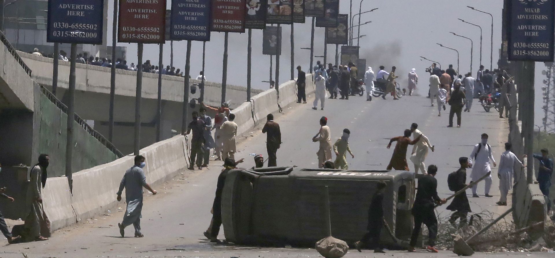 Los partidarios del ex primer ministro de Pakistán, Imran Khan, aplastan un vehículo policial durante una protesta contra el arresto de su líder, en Peshawar, Pakistán, el miércoles 10 de mayo de 2023. (Foto AP/Muhammad Sajjad)