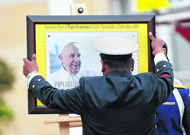 Preparativos. Un empleado instala una imagen del Papa frente al Palacio Presidencial