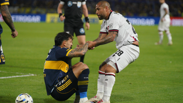 Gaspar Iñíguez levanta a Paredes. El volante de Newells jugó en un rato en la goleada contra Boca.