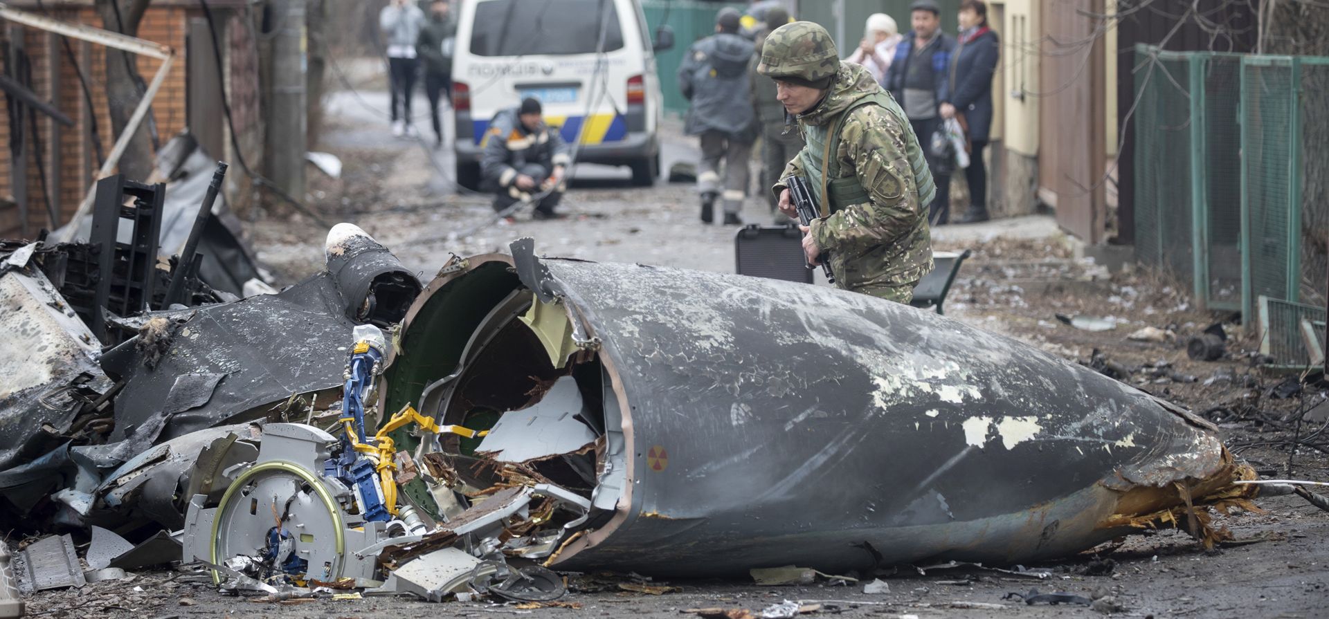 Un soldado del ejército ucraniano inspecciona los fragmentos de un avión derribado en Kiev, Ucrania, el viernes 25 de febrero de 2022.