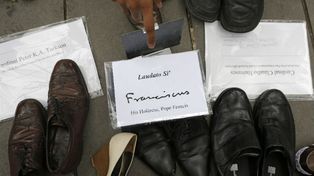 Un par de zapatos del Papa encabezan en París la marcha contra el cambio climático