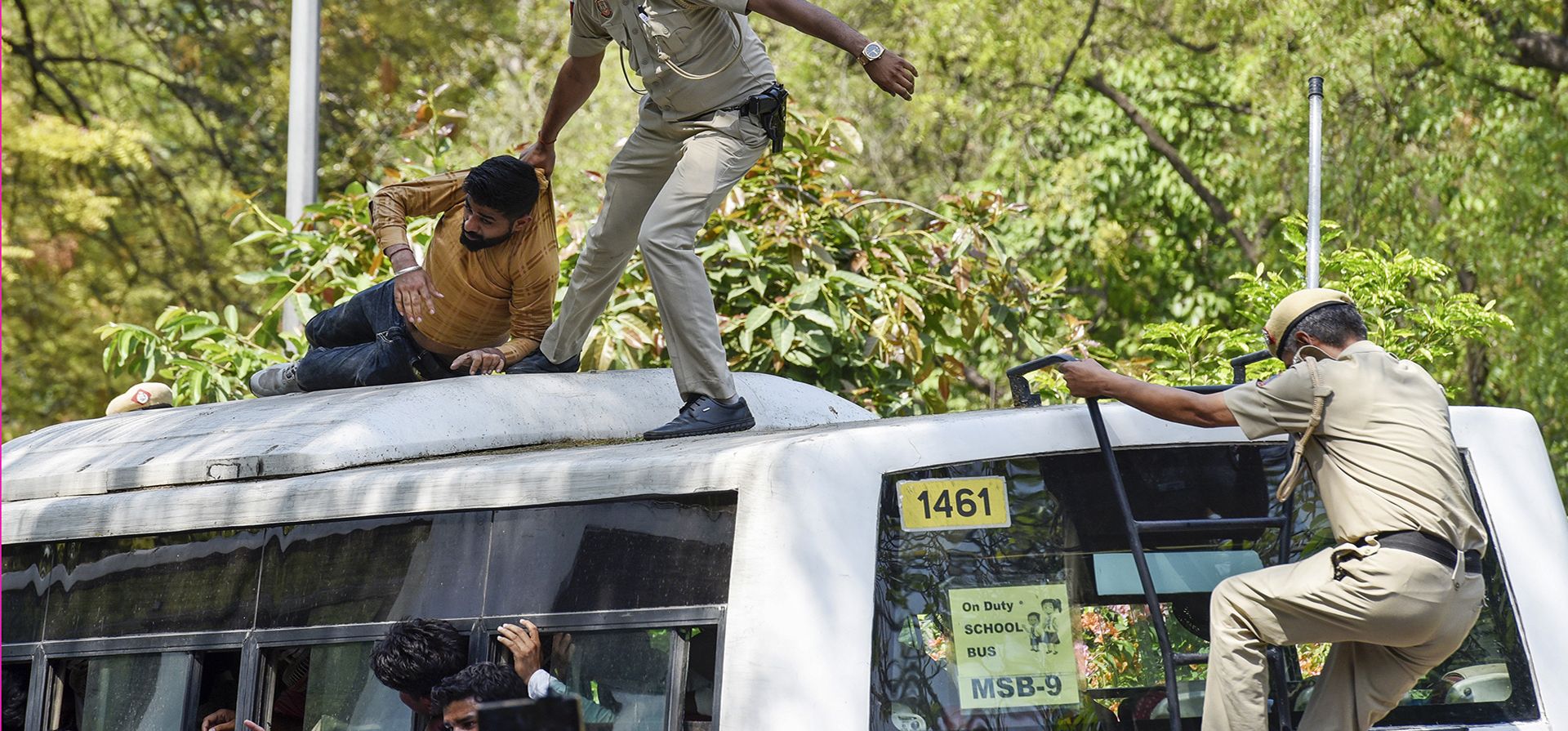 Un policía arrastra a un partidario del opositor Partido del Congreso sobre un vehículo policial mientras son detenidos por protestar contra la expulsión de su líder Rahul Gandhi del Parlamento en Nueva Delhi, India, el lunes 27 de marzo de 2023. (Foto AP/Deepanshu Aggarwal