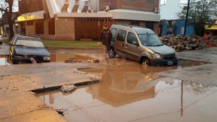 Dos autos cayeron en un bache lleno de agua de la lluvia