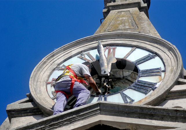 Limpieza. Un operario de la empresa lleva adelante la refacción del antiguo reloj de la parroquia.