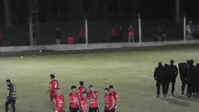 Los jugadores se quedaron esperando la decisión del juez ante los disturbios que se produjeron alrededor de la cancha. (Foto: portalpellegrinense)
