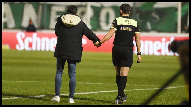 Cristian González y el cuarto árbitro se dan la mano luego de varias discusiones.