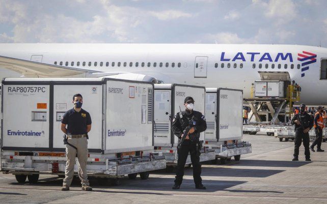 Guardias de seguridad protegen contenedores con dos millones de dosis de vacuna contra el coronavirus fabricadas por la farmacéutica china Sinovac Biotech en el aeropuerto Arturo Merino Benítez de Santiago, Chile.