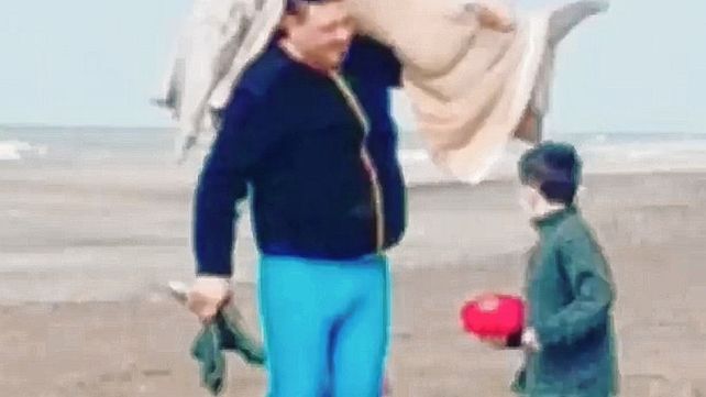 El hombre carga con el Delfín envuelto en una frazada.