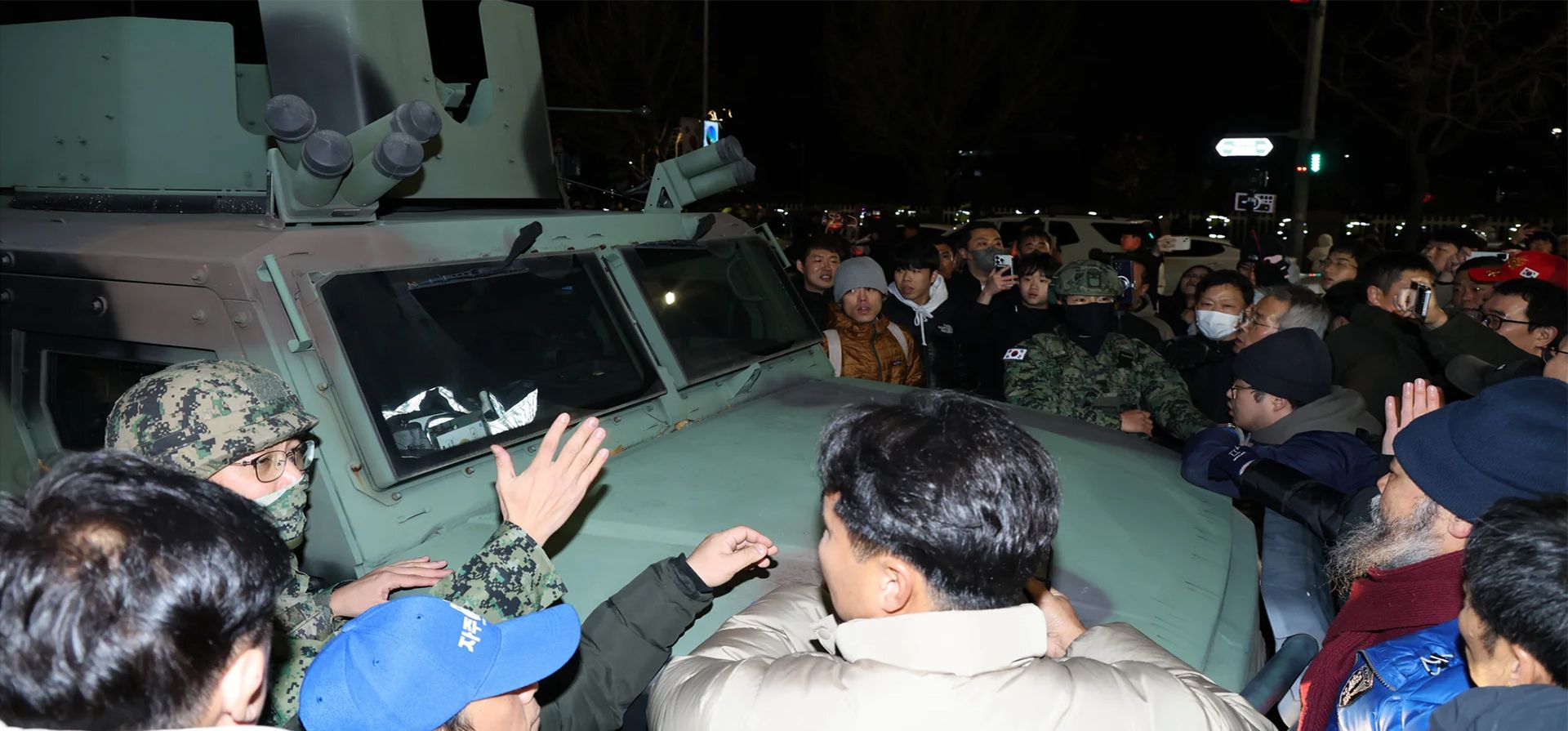 La gente rodea un vehículo militar frente a la Asamblea Nacional en Seúl. Fotografía: Han Myung-gu/EPA La gente rodea un vehículo militar frente a la Asamblea Nacional en Seúl. Fotografía: Han Myung-gu/EPA