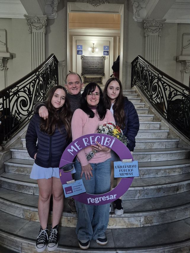 Foto tradicional. La egresada y su familia frente a las escalinatas de la Facultad de Ciencias Médicas.