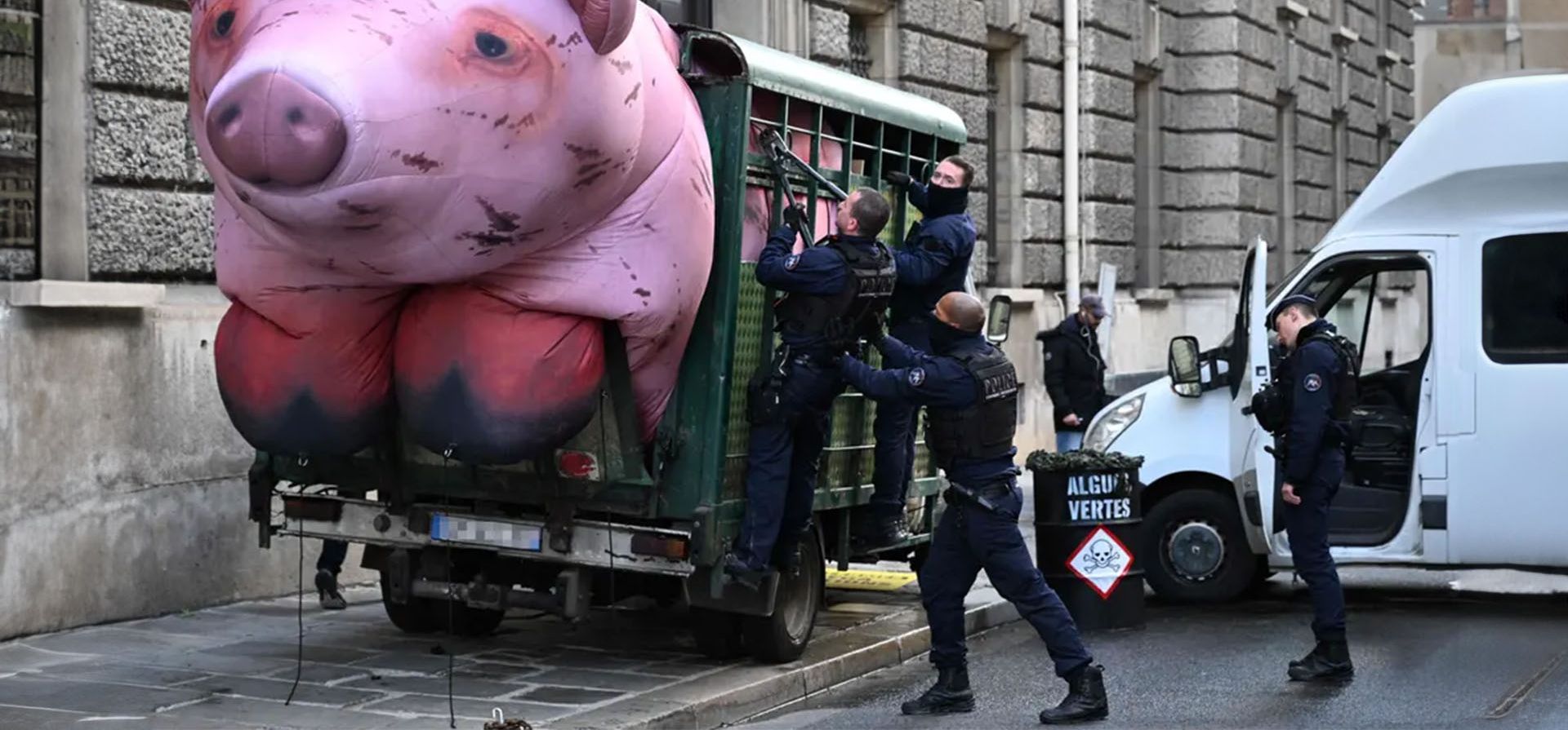 La policía intenta desmantelar un cerdo inflable gigante en un remolque que bloquea una calle cerca del Ministerio de Agricultura durante una protesta de Greenpeace contra las políticas agrícolas y el impacto ecológico de la agricultura industrializada, París, Francia. Fotografía: Miguel Medina/AFP/Getty Images La policía intenta desmantelar un cerdo inflable gigante en un remolque que bloquea una calle cerca del Ministerio de Agricultura durante una protesta de Greenpeace contra las políticas agrícolas y el impacto ecológico de la agricultura industrializada, París, Francia. Fotografía: Miguel Medina/AFP/Getty Images