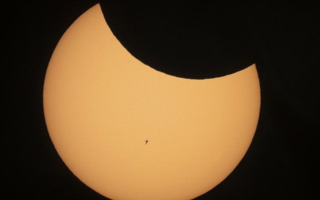 La silueta de un pájaro se recorta contra el sol mientras la luna bloquea una parte durante un eclipse solar parcial en San Petersburgo, Rusia.