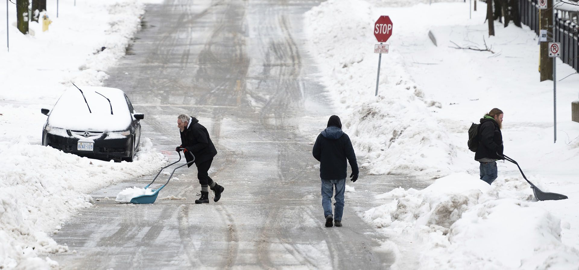 La gente palea la nieve en el vecindario Sandy Hill de Ottawa, el viernes 23 de diciembre de 2022. Environment Canada emitió una advertencia de tormenta invernal para la región que exige heladas repentinas, superficies heladas y resbaladizas y fuertes ráfagas de viento. (Spencer Colby/The Canadian Press vía AP)