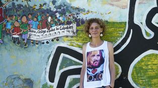 Celeste Lepratti posa junto a un mural que recuerda la lucha social de su hermano Pocho, asesinado por la policía de Santa Fe en la revuelta social de 2001.
