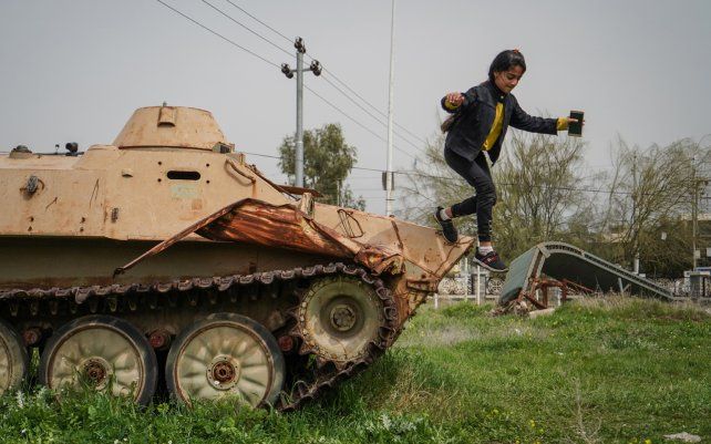 Una niña juega en la parte superior de un vehículo militar que fue utilizado en el ataque químico llevado a cabo por el gobierno iraquí el 16 de marzo de 1988, durante los últimos días de la guerra Irán-Irak en la ciudad kurda de Halabja.