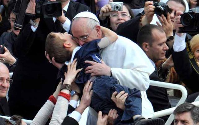 El Santo Padre. Jorge Bergoglio besó especialmente a un niño enfermo que le acercaron ayer en la plaza San Pedro.