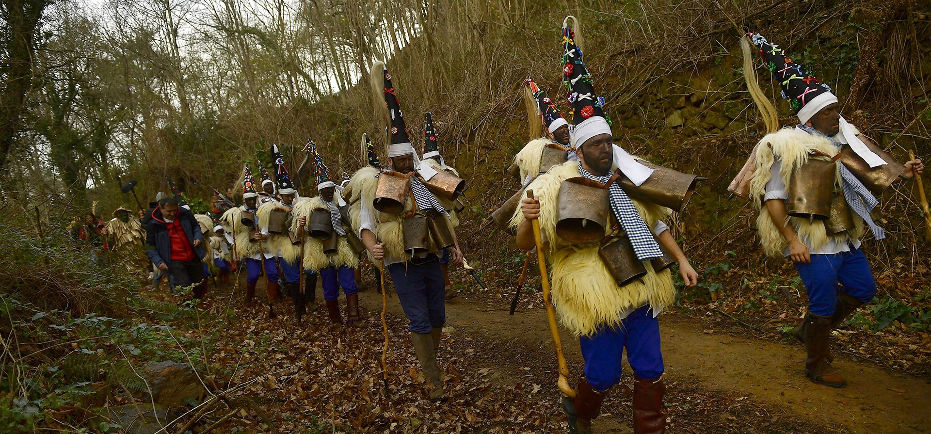 Hombres vestidos con pieles de oveja y tintineando cascabeles para hacer ruido, marchan durante la tradicional fiesta milenaria