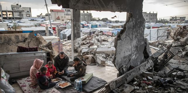 Muhammad al-Durra, un palestino cuya casa fue destruida en un ataque israelí y que perdió a su esposa, rompe el ayuno con sus hijos, Rafah, Gaza. Fotografía: Anadolu/Getty Images