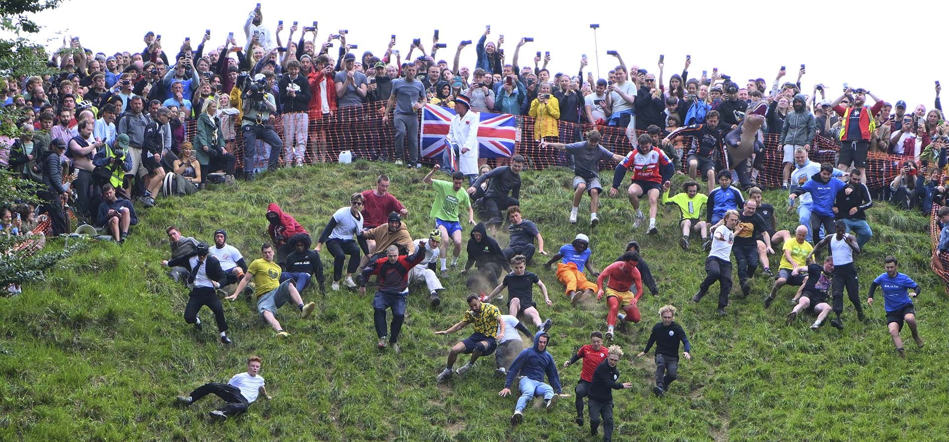 Un grupo de competidores comienzan la carrera de descenso masculina en el tradicional concurso anual Cheese Rolling en Cooper's Hill en Brockworth, Gloucestershire, Inglaterra, el lunes 26 de mayo de 2025. (Foto AP/Anthony Upton) Un grupo de competidores comienzan la carrera de descenso masculina en el tradicional concurso anual Cheese Rolling en Cooper's Hill en Brockworth, Gloucestershire, Inglaterra, el lunes 26 de mayo de 2025. (Foto AP/Anthony Upton)