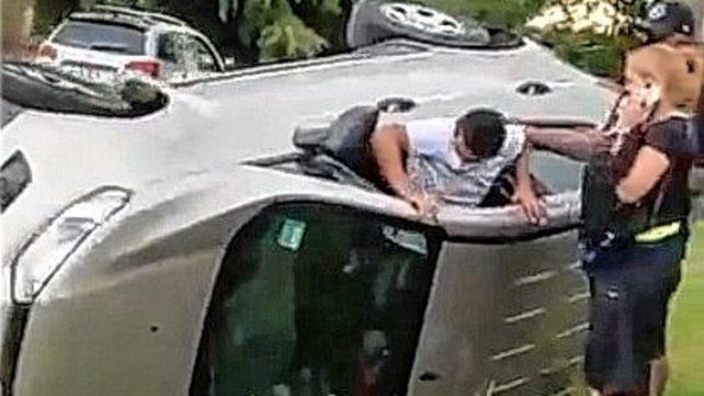 El Pulga Rodríguez sale del auto siniestrado luego de auxiliar a la mujer que conducía.