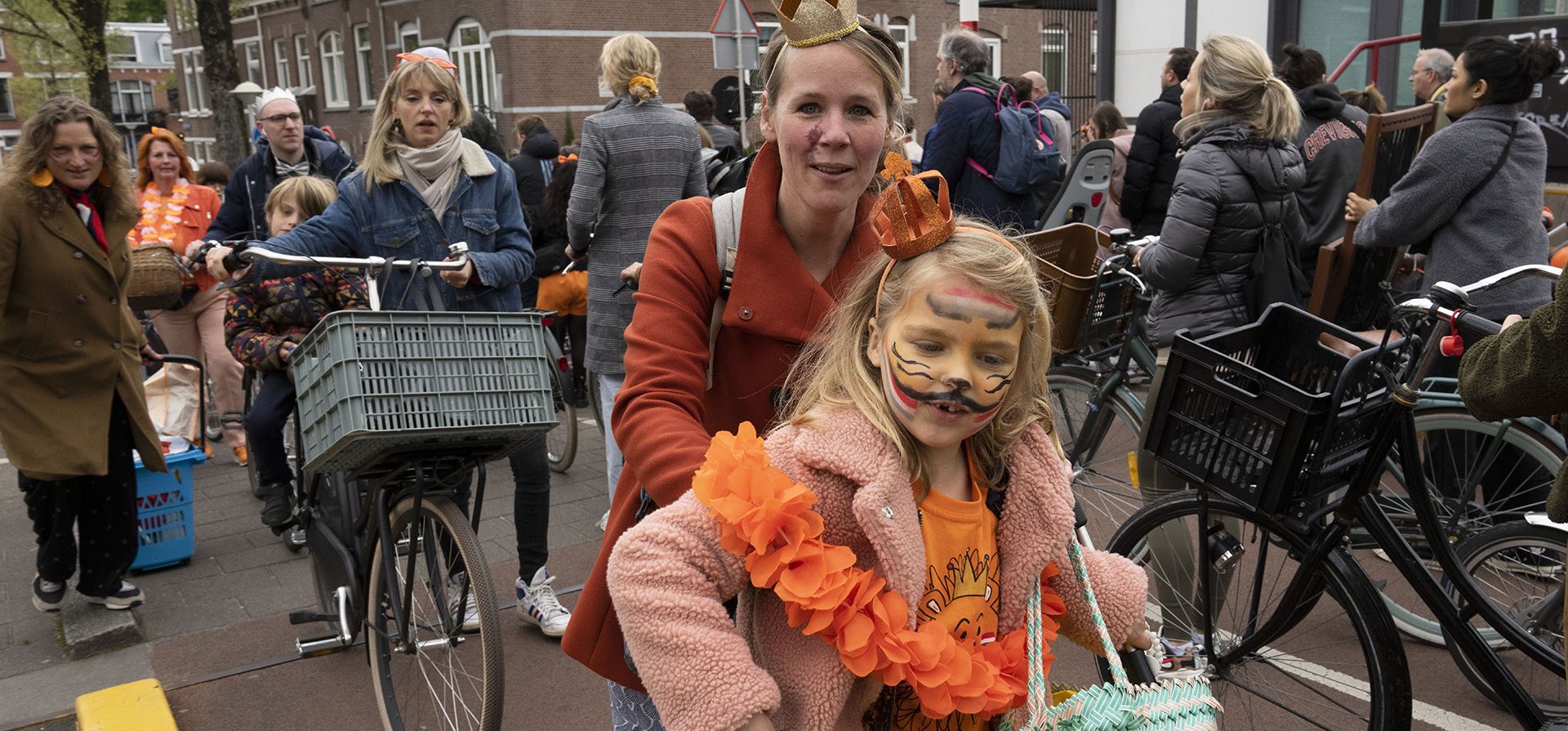 Personas vestidas de naranja se dirigen a Vondelpark después de hacer cola en un puente levadizo para dejar pasar a los barcos durante las celebraciones del Día del Rey en Ámsterdam, Países Bajos, el miércoles 27 de abril de 2022. Después de dos años de celebraciones silenciadas por los cierres de coronavirus, los Países Bajos celebraron el 55º aniversario del Rey Willem-Alexander de la Casa de Orange.
