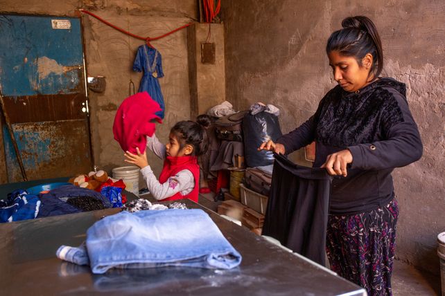 Una niña pequeña ayuda a su madre en las tareas domésticas.