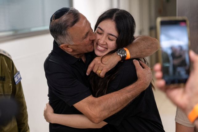 La joven es besada por su padre este sábado en un hospital donde la asistieron apenas arribada a suelo israelí.