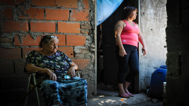 La esposa y la suegra de Ramos en el patio de la casa donde ocurrió el crimen la tarde del martes.
