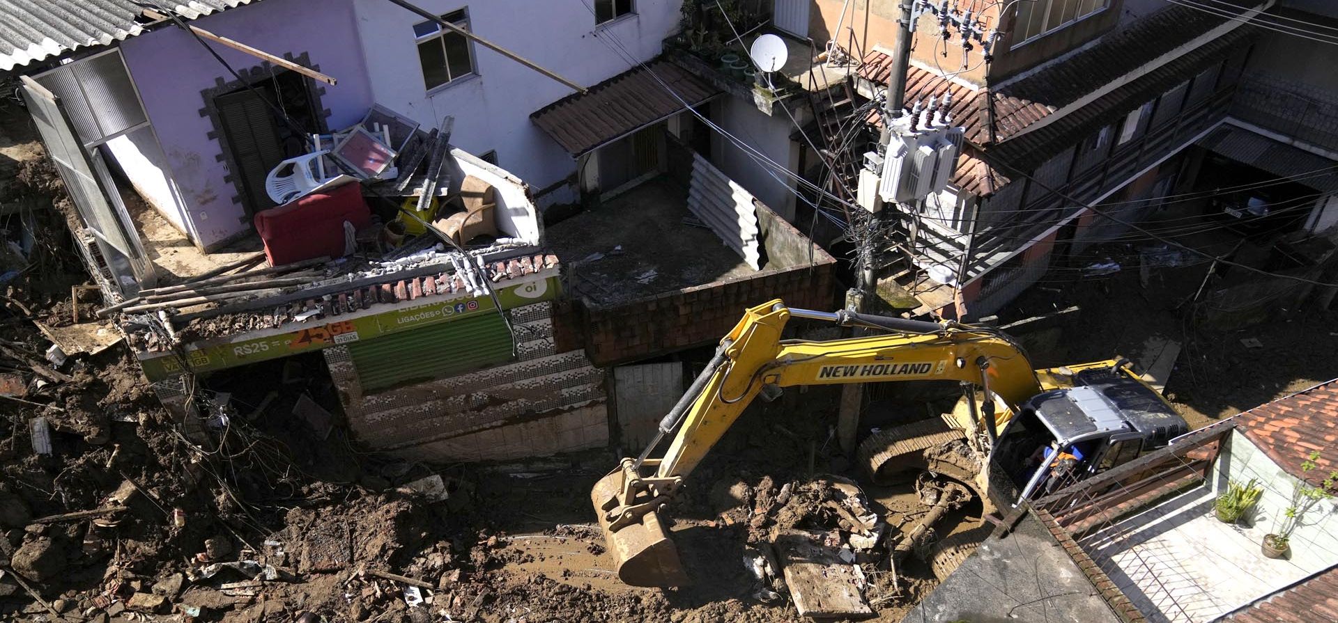 Una excavadora limpia el lodo de una calle en Petrópolis, Brasil, el jueves 17 de febrero de 2022. Las inundaciones y los deslizamientos de tierra arrasaron con casas y automóviles, pero incluso cuando las familias se preparaban para enterrar a sus muertos, no estaba claro cuántos cuerpos quedaron atrapados en el lodo.