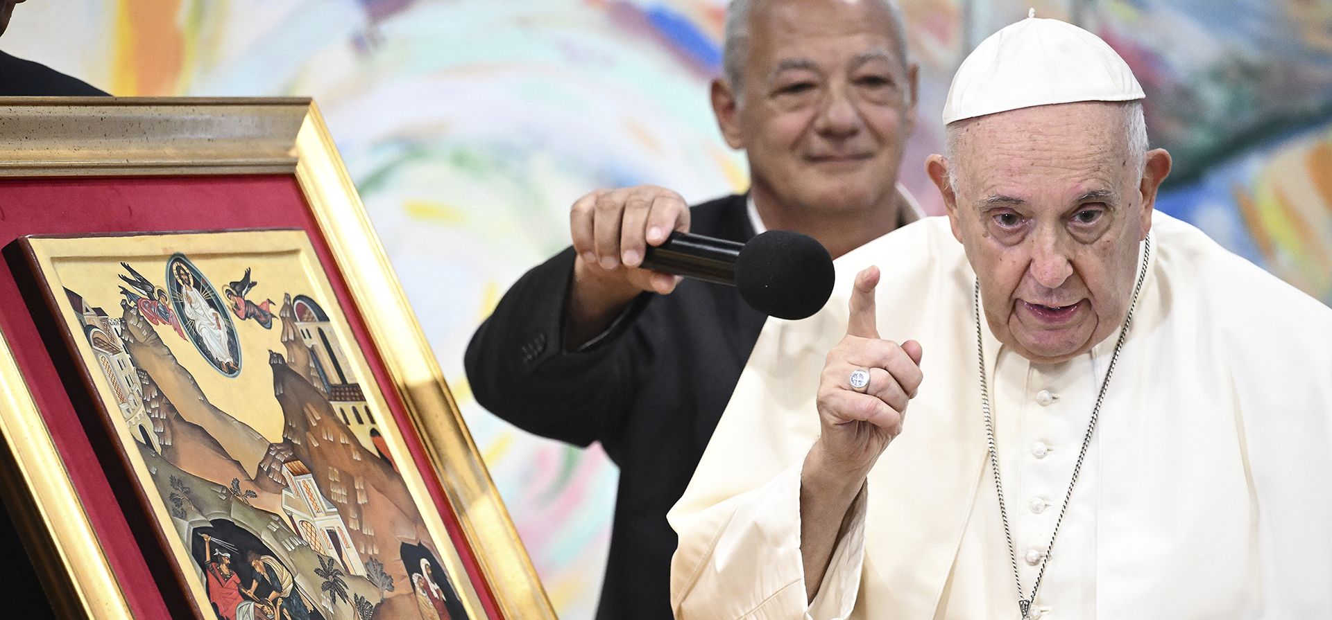 El Papa Francisco es ayudado con un micrófono por el presidente de Scholas Occurrentes, José María del Corral, mientras hace comentarios sobre una pintura que representa la parábola del "buen samaritano" durante una reunión con miembros de la comunidad de jóvenes Scholas Occurrentes, un Movimiento educativo internacional creado por el mismo Papa Francisco, en Cascais, 25 kilómetros al sur de Lisboa, el jueves 3 de agosto de 2023. (Piscina de Marco Bertorello vía AP) El Papa Francisco es ayudado con un micrófono por el presidente de Scholas Occurrentes, José María del Corral, mientras hace comentarios sobre una pintura que representa la parábola del "buen samaritano" durante una reunión con miembros de la comunidad de jóvenes Scholas Occurrentes, un Movimiento educativo internacional creado por el mismo Papa Francisco, en Cascais, 25 kilómetros al sur de Lisboa, el jueves 3 de agosto de 2023. (Piscina de Marco Bertorello vía AP)