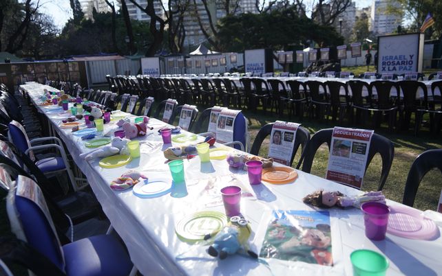 Pedido de liberación. Las mesas y sillas con los rostros de los 242 rehenes se exhiben en el stand de Israel en Colectividades.