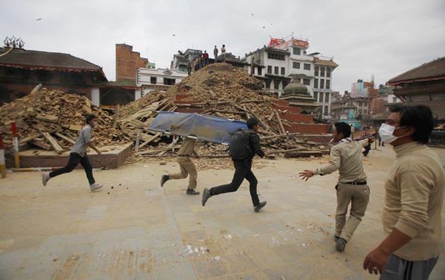 Devastador. Voluntarios corren para asistir a personas que quedaron atrapadas entre los escombros de edificios y templos de la ciudad de Katmandú.